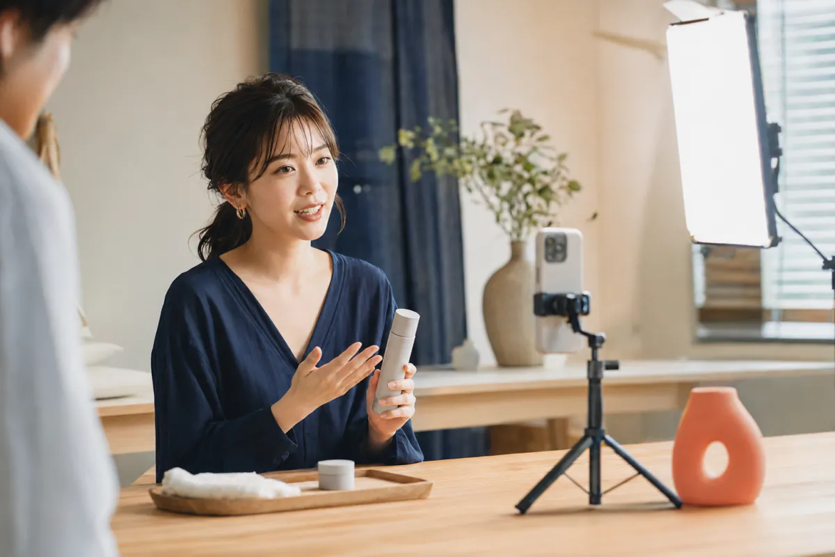 コマーサーがスマートフォンの前で商品を紹介している様子